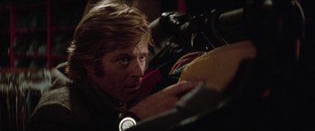 Movie still from “Three Days of the Condor” (1975), directed by Sydney Pollack – A person with a camera; Close Up shot, Low angle