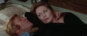 Movie still from “Three Days of the Condor” (1975), directed by Sydney Pollack – A man and a woman laying on a bed together; Close Up shot, High angle