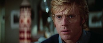 Movie still from “Three Days of the Condor” (1975), directed by Sydney Pollack – A person wearing glasses and a jacket; Close Up shot, Low angle