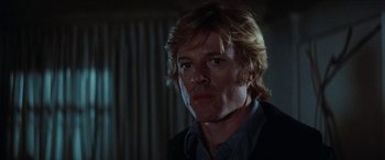 Movie still from “Three Days of the Condor” (1975), directed by Sydney Pollack – A person wearing a suit and tie; Close Up shot, Over the shoulder angle