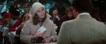 Movie still from “Three Days of the Condor” (1975), directed by Sydney Pollack – A woman in a white hat holding a piece of paper in her hand; Medium shot, Over the shoulder angle