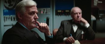 Movie still from “Three Days of the Condor” (1975), directed by Sydney Pollack – Two men in suits sitting at a conference table; Close Up shot, Over the shoulder angle