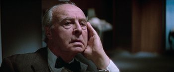 Movie still from “Three Days of the Condor” (1975), directed by Sydney Pollack – An older man in a white shirt and a black bow tie; Close Up shot, Low angle