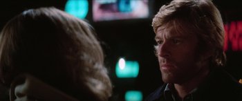 Movie still from “Three Days of the Condor” (1975), directed by Sydney Pollack – A man and a woman are talking to each other in a room; Close Up shot, Over the shoulder angle