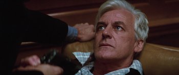 Movie still from “Three Days of the Condor” (1975), directed by Sydney Pollack – An older man is blow - drying his hair; Close Up shot, Over the shoulder angle