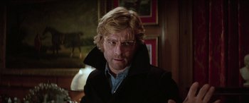 Movie still from “Three Days of the Condor” (1975), directed by Sydney Pollack – A person wearing glasses and a jacket; Close Up shot, Low angle