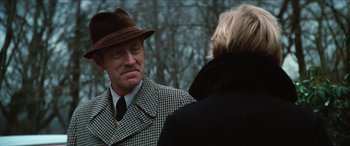 Movie still from “Three Days of the Condor” (1975), directed by Sydney Pollack – A man wearing a hat talking to a woman; Close Up shot, Over the shoulder angle