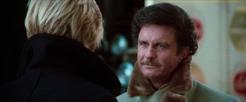 Movie still from “Three Days of the Condor” (1975), directed by Sydney Pollack – A man in a fur coat is looking at another man in a fur coat; Close Up shot, Over the shoulder angle