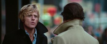 Movie still from “Three Days of the Condor” (1975), directed by Sydney Pollack – A man is talking to another man on the street; Close Up shot, Over the shoulder angle