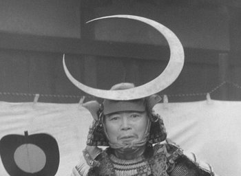 Movie still from “Throne of Blood” (1957), directed by Akira Kurosawa – An old photo of a person wearing a helmet with horns on top of their head; Close Up shot, Low angle