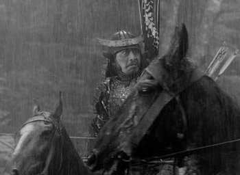 Movie still from “Throne of Blood” (1957), directed by Akira Kurosawa – A man riding on the back of a horse in the rain; Medium shot, Low angle