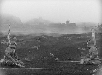 Movie still from “Throne of Blood” (1957), directed by Akira Kurosawa – Two men are sitting in the middle of a field; Wide shot, High angle