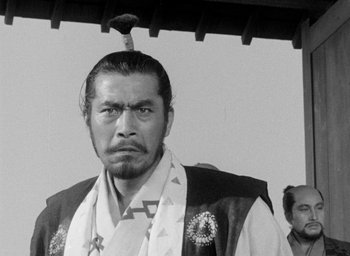 Movie still from “Throne of Blood” (1957), directed by Akira Kurosawa – A man with a bird on top of his head; Close Up shot, Low angle