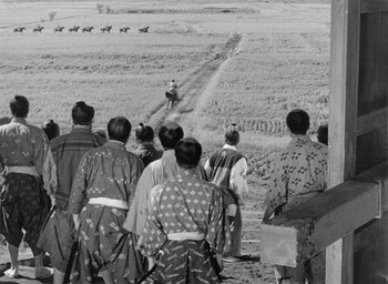 Movie still from “Throne of Blood” (1957), directed by Akira Kurosawa – A black and white photo of a group of people in a field; Extreme Wide shot, High angle