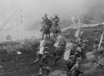 Movie still from “Throne of Blood” (1957), directed by Akira Kurosawa – A black and white photo of a group of men on horseback; Extreme Wide shot, High angle