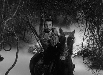 Movie still from “Throne of Blood” (1957), directed by Akira Kurosawa – A black and white photo of a man riding a horse; Wide shot, High angle