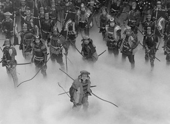 Movie still from “Throne of Blood” (1957), directed by Akira Kurosawa – A large group of people dressed in samurai garb; Wide shot, High angle