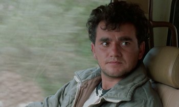 Movie still from “Through the Olive Trees” (1994), directed by Abbas Kiarostami – A person wearing a jacket; Close Up shot, Low angle