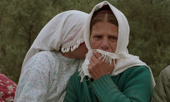 Movie still from “Through the Olive Trees” (1994), directed by Abbas Kiarostami – A woman covering her face with a white scarf; Close Up shot, Over the shoulder angle