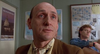 Movie still from “Throw Momma from the Train” (1987), directed by Danny DeVito – A man with a bald head looking up at the sky; Close Up shot, Low angle