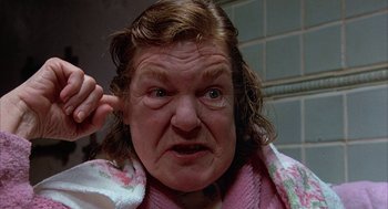 Movie still from “Throw Momma from the Train” (1987), directed by Danny DeVito – An older woman with a towel around her neck; Close Up shot, High angle