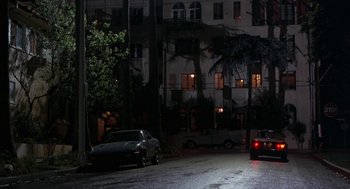 Movie still from “Throw Momma from the Train” (1987), directed by Danny DeVito – Cars parked on the side of the street at night; Extreme Wide shot, Low angle