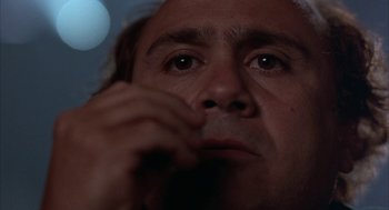 Movie still from “Throw Momma from the Train” (1987), directed by Danny DeVito – A man's face with his hand to his face; Extreme Close Up shot, Low angle