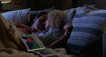 Movie still from “Throw Momma from the Train” (1987), directed by Danny DeVito – A man and a woman laying on a bed reading a book; Medium shot, Overhead angle