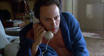 Movie still from “Throw Momma from the Train” (1987), directed by Danny DeVito – A man in a blue robe talking on a phone; Close Up shot, High angle
