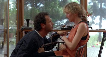 Movie still from “Throw Momma from the Train” (1987), directed by Danny DeVito – A man and a woman sitting in a chair; Medium shot, Over the shoulder angle