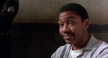 Movie still from “Throw Momma from the Train” (1987), directed by Danny DeVito – A person wearing a white shirt; Close Up shot, Low angle