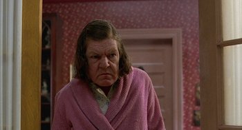 Movie still from “Throw Momma from the Train” (1987), directed by Danny DeVito – An older woman in a pink robe looking angry at the camera; Close Up shot, Low angle