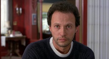 Movie still from “Throw Momma from the Train” (1987), directed by Danny DeVito – A person wearing a sweater and looking at the camera; Close Up shot, Low angle