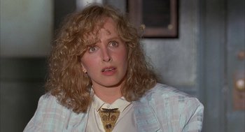 Movie still from “Throw Momma from the Train” (1987), directed by Danny DeVito – A person with curly hair wearing a jacket; Close Up shot, Over the shoulder angle