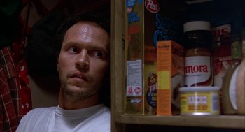 Movie still from “Throw Momma from the Train” (1987), directed by Danny DeVito – A person in a cupboard; Close Up shot, Low angle