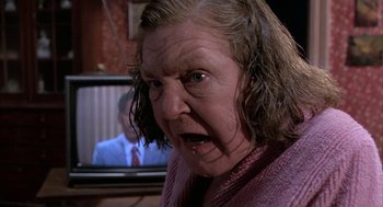 Movie still from “Throw Momma from the Train” (1987), directed by Danny DeVito – An older woman with a surprised look on her face; Close Up shot, Over the shoulder angle