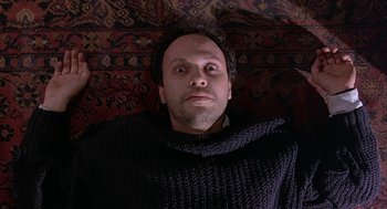 Movie still from “Throw Momma from the Train” (1987), directed by Danny DeVito – A man laying on the ground looking up at the camera; Close Up shot, Overhead angle