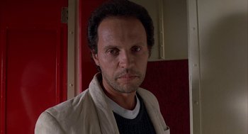 Movie still from “Throw Momma from the Train” (1987), directed by Danny DeVito – A person wearing a jacket and looking at the camera; Close Up shot, Low angle