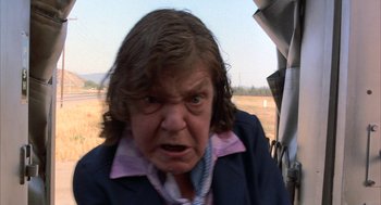 Movie still from “Throw Momma from the Train” (1987), directed by Danny DeVito – An older woman with a frowning look on her face; Close Up shot, Low angle