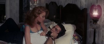 Movie still from “Thunderball” (1965), directed by Terence Young – A man laying in a bed with a woman; Medium shot, High angle