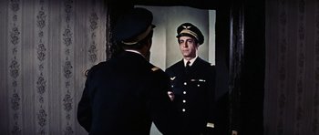 Movie still from “Thunderball” (1965), directed by Terence Young – A man in a military uniform looking at himself in a mirror; Medium shot, Over the shoulder angle