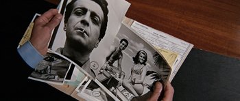 Movie still from “Thunderball” (1965), directed by Terence Young – A person holding up an old photo of a man and a woman; Extreme Close Up shot, Overhead angle