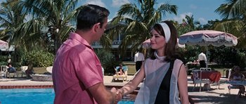 Movie still from “Thunderball” (1965), directed by Terence Young – A man and a woman shaking hands in front of a swimming pool; Medium shot, Over the shoulder angle