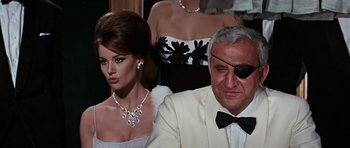 Movie still from “Thunderball” (1965), directed by Terence Young – A man and a woman in a white suit and tie; Close Up shot, Over the shoulder angle