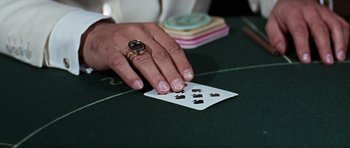 Movie still from “Thunderball” (1965), directed by Terence Young – A person is holding a deck of playing cards on a table; Extreme Close Up shot, High angle