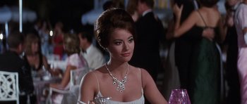 Movie still from “Thunderball” (1965), directed by Terence Young – A woman in a white dress and a necklace; Close Up shot, Over the shoulder angle