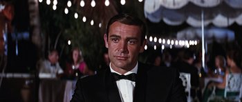 Movie still from “Thunderball” (1965), directed by Terence Young – A man in a suit and bow tie; Close Up shot, Low angle