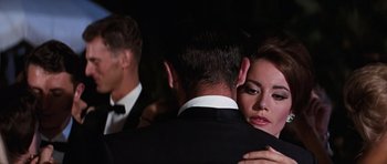 Movie still from “Thunderball” (1965), directed by Terence Young – A man and a woman hugging in front of another man; Close Up shot, Over the shoulder angle