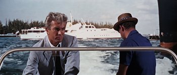 Movie still from “Thunderball” (1965), directed by Terence Young – Two men are sitting on a boat in the water; Medium shot, Over the shoulder angle