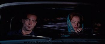 Movie still from “Thunderball” (1965), directed by Terence Young – A man and a woman sitting in the back of a car; Close Up shot, Low angle